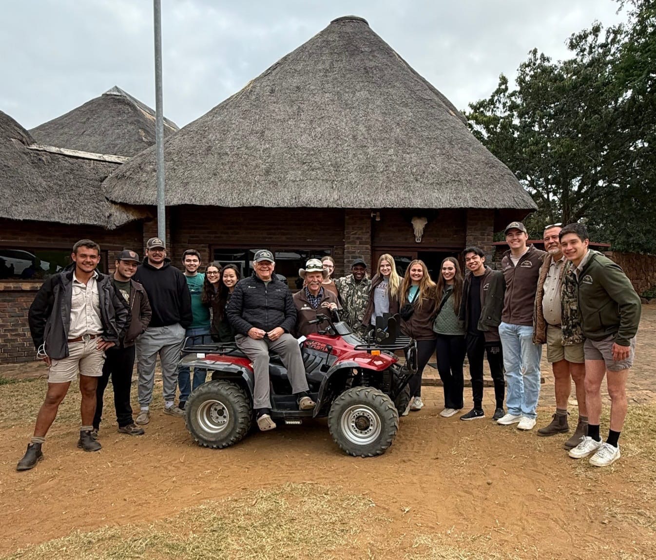 A university group gathered in front of the thatched Seringa lodge